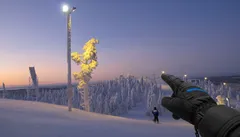 Talvinen maisema, lumisia puita ja käsi osoittaa viileässä Lapin tunturissa
